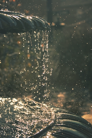 капли воды стекают с чаши фонтана 