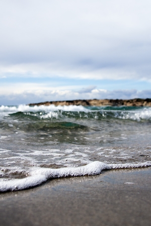 Океанская волна мчится к пляжному берегу, пляж, голубая вода, голубое небо