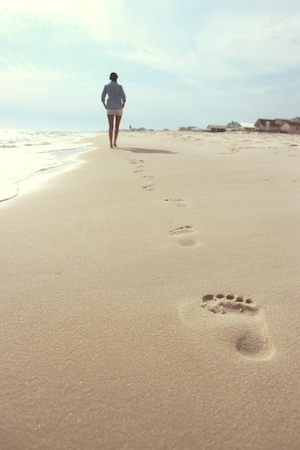 следы человека, идущего по песчаному пляжу