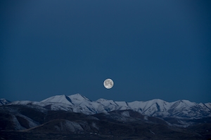 Полная луна над снежными горами