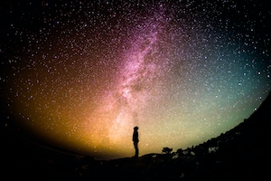 панорама звездного неба с силуэтом человека 
