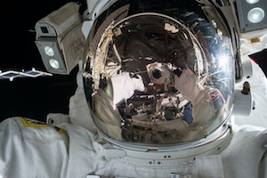 космонавт в открытом космосе, скафандр, шлем, крупный план 