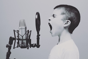мальчик кричит в микрофон, черно-белая фотография 