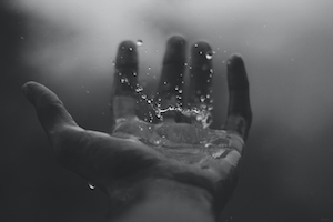 капли воды в руке человека 
