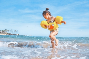 Счастливый ребенок, играющий на пляже