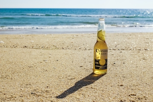 Пиво на песчаном пляже, голубая вода 