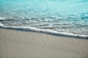 Океанская пена на песчаном пляже