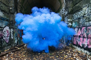 синее облако дыма на фоне стен с граффити 