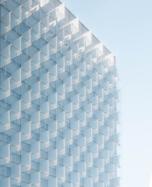 Стеклянный фасад многоэтажного дома, голубое небо
