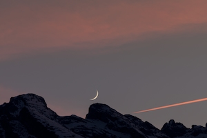 Закат луны над Швейцарскими Альпами, полумесяц на небе во время заката, облака 
