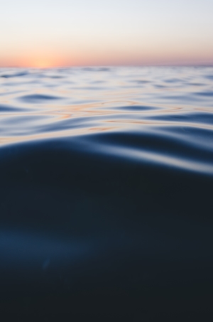 Успокаивающая рябь, образованная набегающими приливами, поверхность моря во время заката 