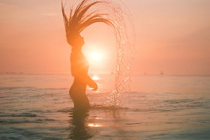закат на море, пляж во время заката, силуэт девушки напротив солнца 