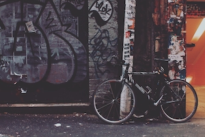 Городской гранж, велосипед стоит у стены с граффити 