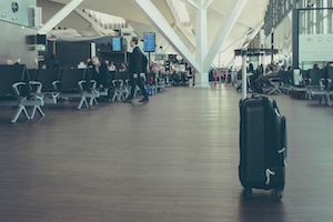 Черный чемодан на переднем плане в аэропорту Гданьска