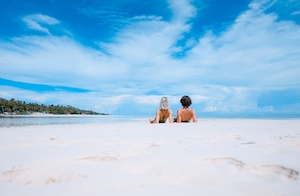 Белые пески, песчаный пляж, море, небо, голубая вода, два человека отдыхают на белом песке у моря 