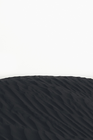 гора черного песка на белом фоне, минималистичная черно-белая фотография 