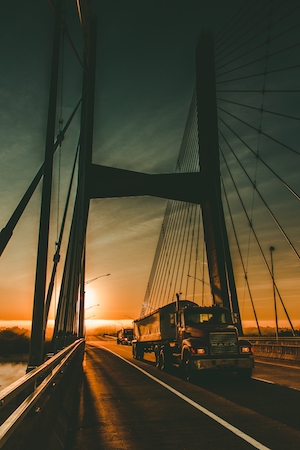 Грузовик на мосту в закатном солнце