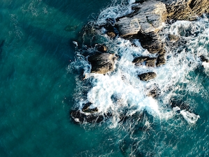 морская пена на скалах пляжа, фото сверху 
