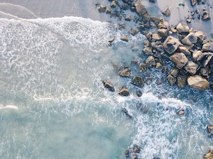 скалистый берег побережья, волны, морская пена, фото сверху 