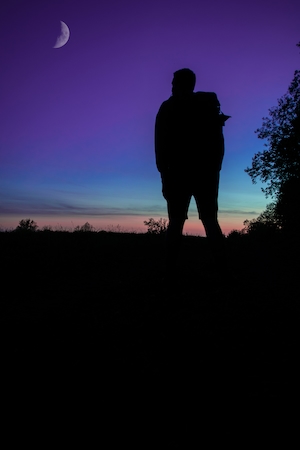 полумесяц на небе во время заката, силуэт человека на фоне фиолетового цвета 