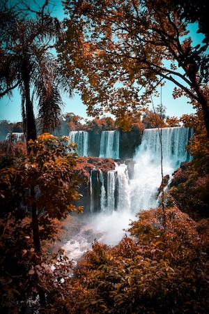 Водопад Игуасу, комплекс каскадных водопадов в окружении осенних листьев 