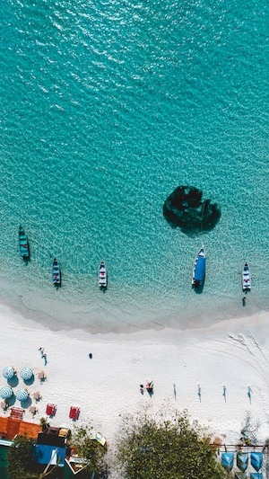 Океан и лодки на островах Перхентиан, Малайзия, бирюзовое побережье с белым песком, фото с воздуха 