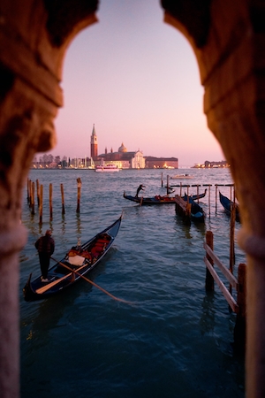 Канал в Венеции на закате, здания на воде, гондола с гондольером 
