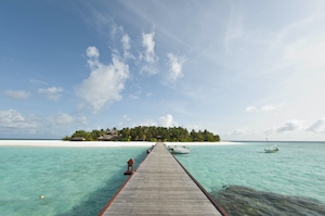 Мальдивы, деревянный мостик к острову с зелеными растениями 