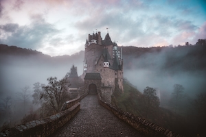 Замок в тумане на фоне леса и неба