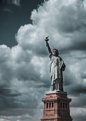 Статуя свобода на фоне серого облачного неба