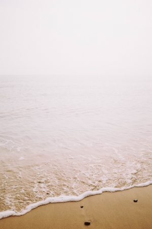 Бледный пейзаж моря у песчаного пляжа 