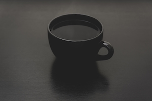 Черная чашка с кофе на черном фоне 