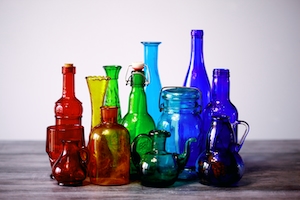 коллекция разноцветных старых стеклянных бутылок и ваз