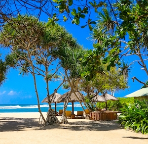 песчаный пляж, море, небо, голубая вода, лежаки с соломенными зонтиками, зеленые пальмы
