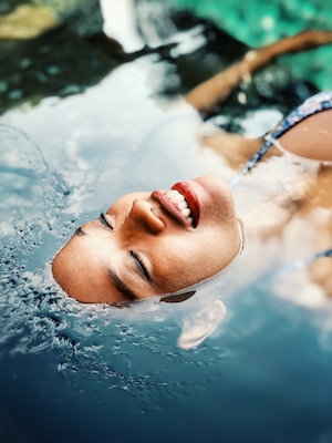 модель погрузила голову под воду, отдыхает на воде, улыбка модели 
