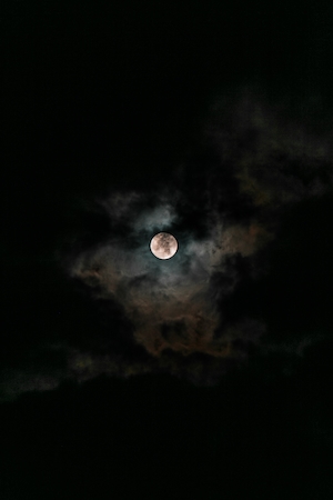 луна на темном небе в облаках 