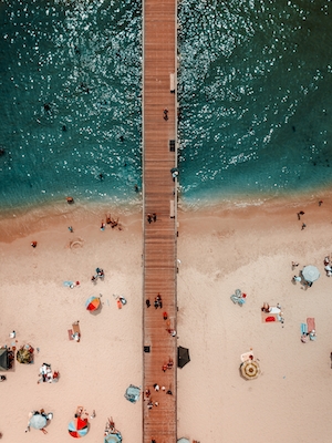 люди отдыхают на пляже, песок и бирюзовая вода, мостик в море, фото сверху 