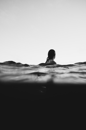 девушка плавает в море, черно-белое фото 