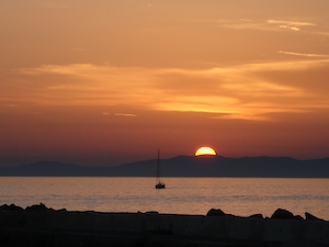 вид на Средиземное море из нашего во время заката, на одинокую лодку, входящую в порт, облака на восходе солнца, восходящее солнце, градиент на небе 