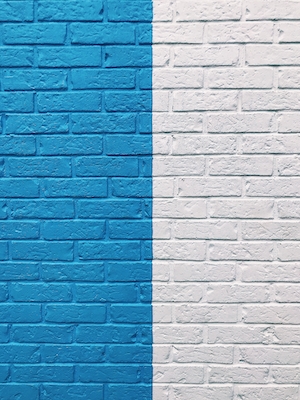 кирпичная стена, разделенная на синюю и белую части 