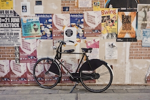 Классический голландский велосипед, лежащий рядом с постерами, плакатами на стене 