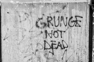 "Гранж не умер" - надпись на бетонной стене, граффити на бетонной стене 