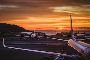 Самолеты в закатное время на взлетно-посадочной полосе 