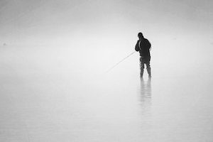 Туманным утром рыбак выходит вброд, чтобы половить немного рыбы. Мир и умиротворение.  Рыбак и вода чрезвычайно тихи и безмятежны.