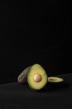 разрезанное авокадо на темном фоне 