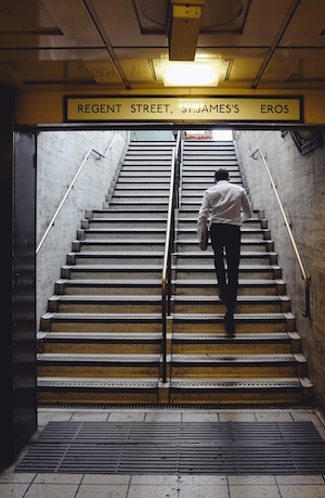 Человек поднимается по лестнице из метро 