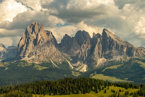 Сассолунго или Лангкофель слева - самая высокая гора группы Лангкофель в Доломитовых Альпах в Южном Тироле, Италия. Горы, облака и леса 