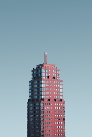 Красный небоскреб на фоне голубого неба