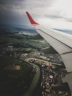 Фото крыла самолета из окна иллюминатора, город 