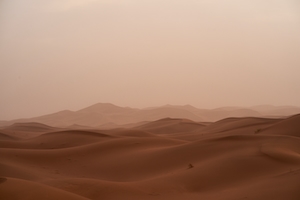 Во время похода по Сахаре с очень сильным ветром в воздухе много песка, похожего на красный туман, песчаная дюна, пески в пустыне, пейзаж в пустыне